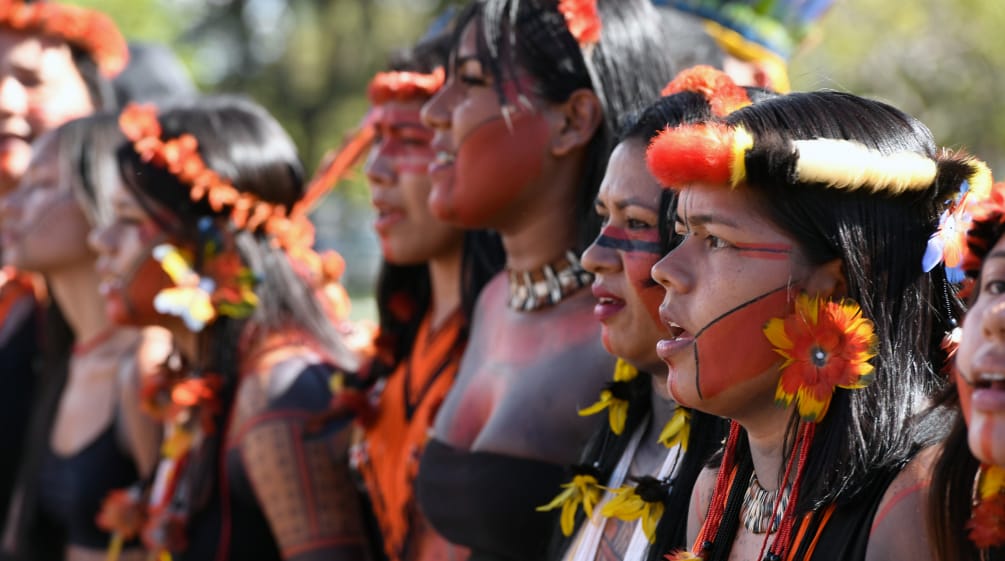 Mit Federn geschmückte junge indigene Frauen